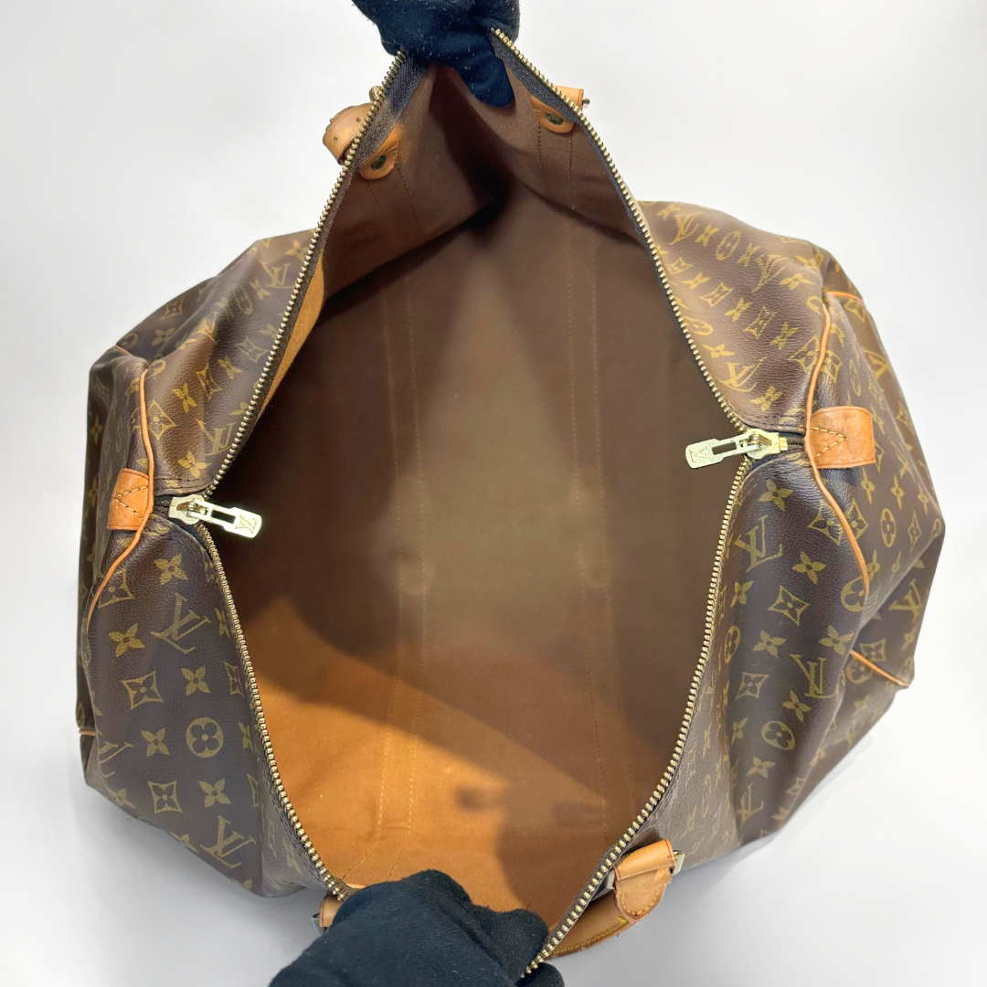 Louis Vuitton monogram bag with open zipper on a white background
