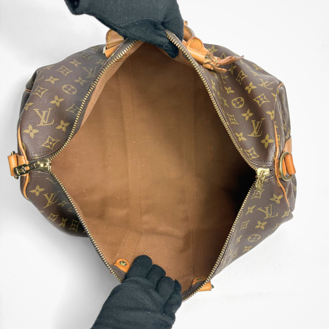 Louis Vuitton monogram handbag with open top showing interior.