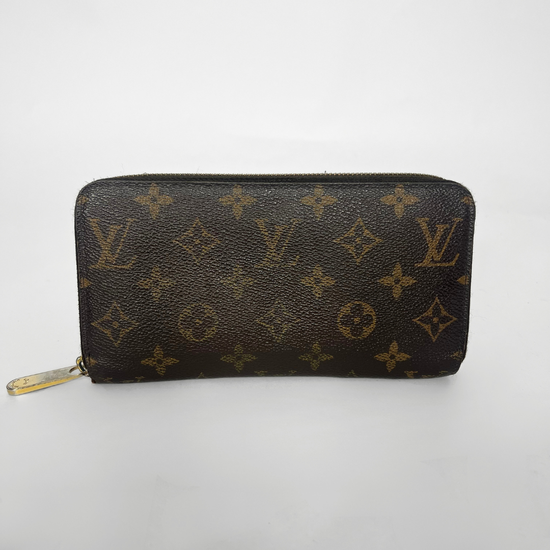 Louis Vuitton wallet with monogram pattern on a white background