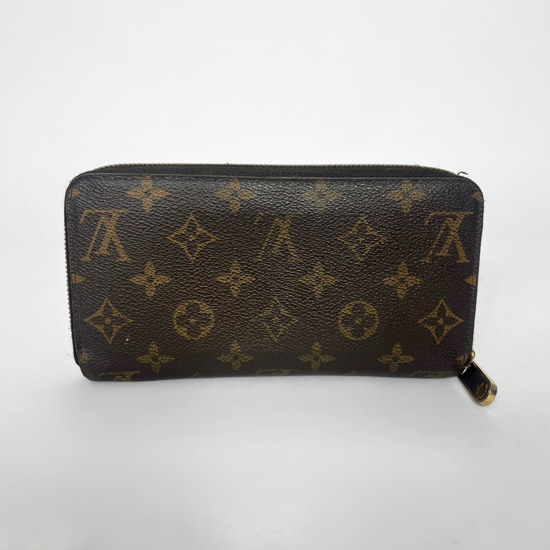 Louis Vuitton wallet with monogram pattern on a white background