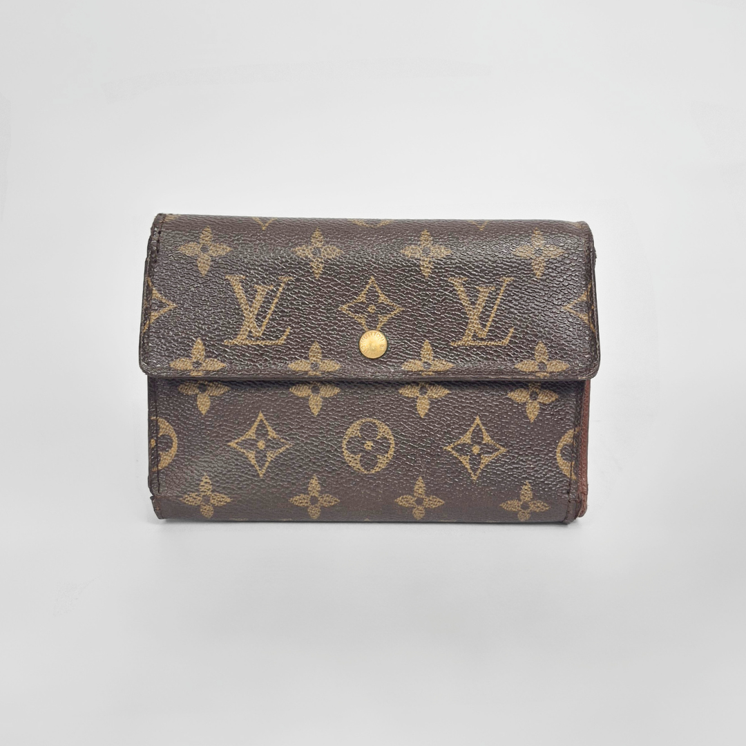 Louis Vuitton wallet with monogram pattern on a light gray background