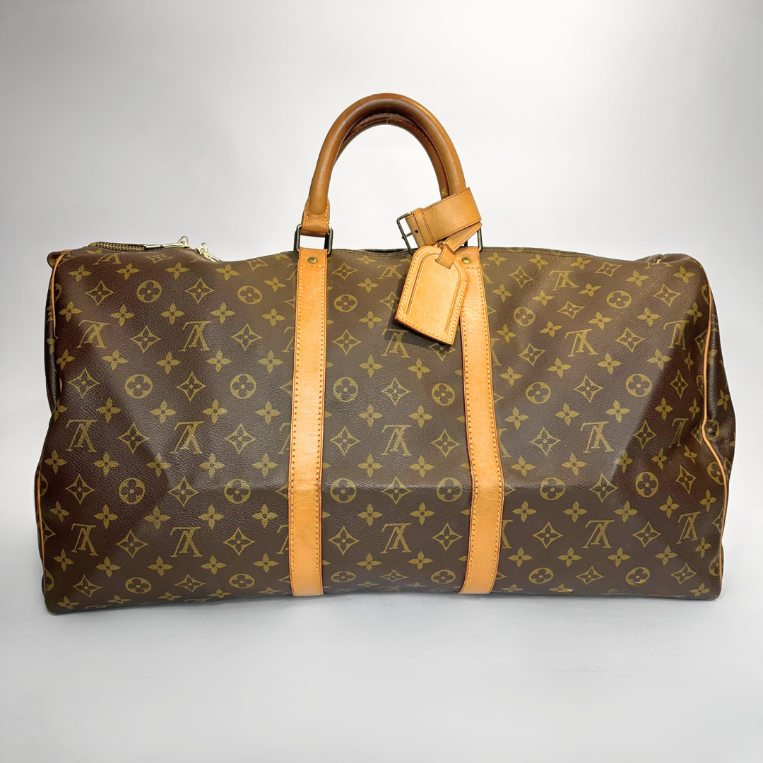 Brown travel bag with yellow monogram pattern on a white background