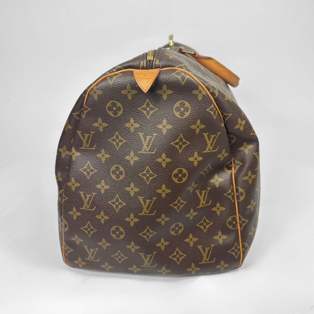 Brown travel bag with tan straps on a white background