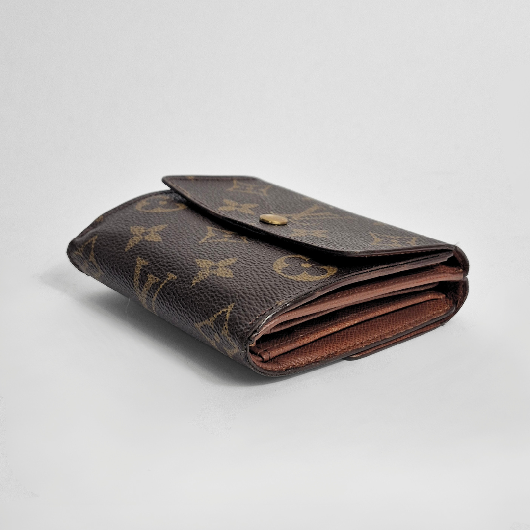 Folded brown wallet with monogram pattern on a light gray background