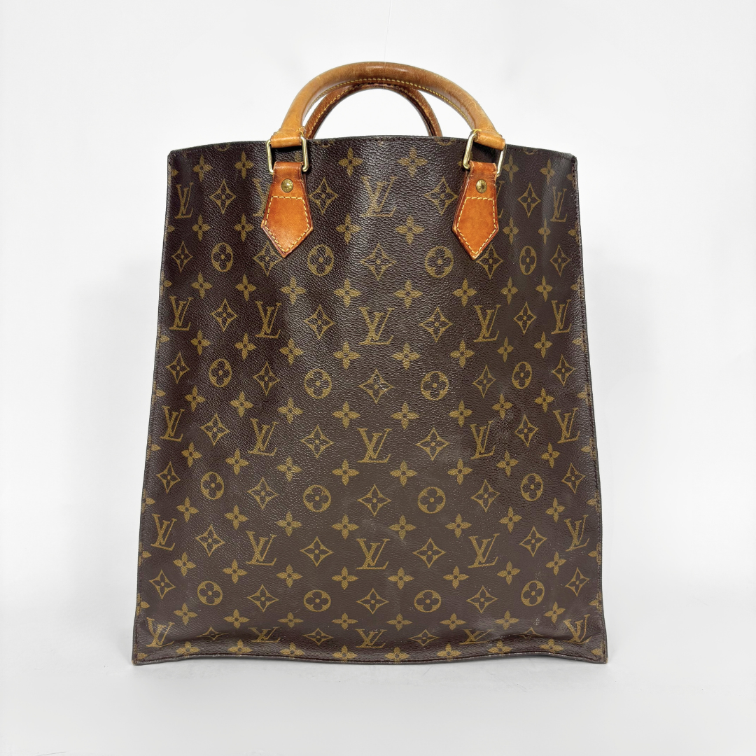 Brown leather bag with monogram pattern on a white background