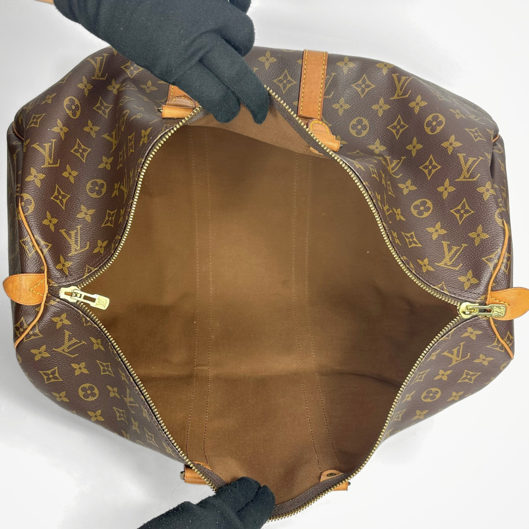 Brown travel bag with tan straps on a white background