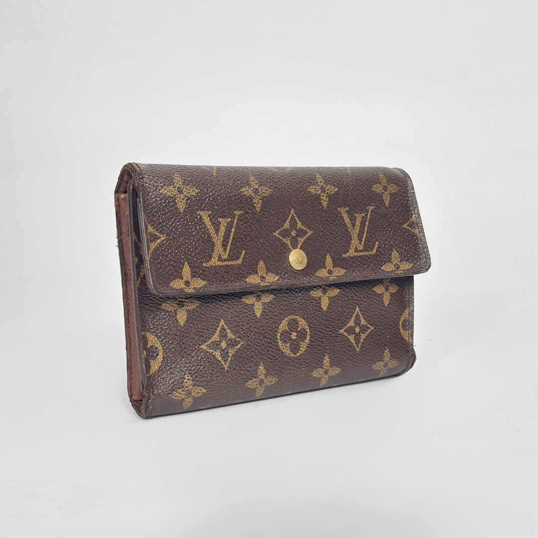 Louis Vuitton wallet with monogram pattern on a light gray background