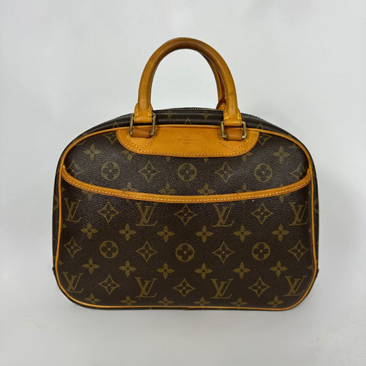 Louis Vuitton Sac à main en toile monogrammée avec anses et finitions en cuir beige, photographié sur un fond clair uni.