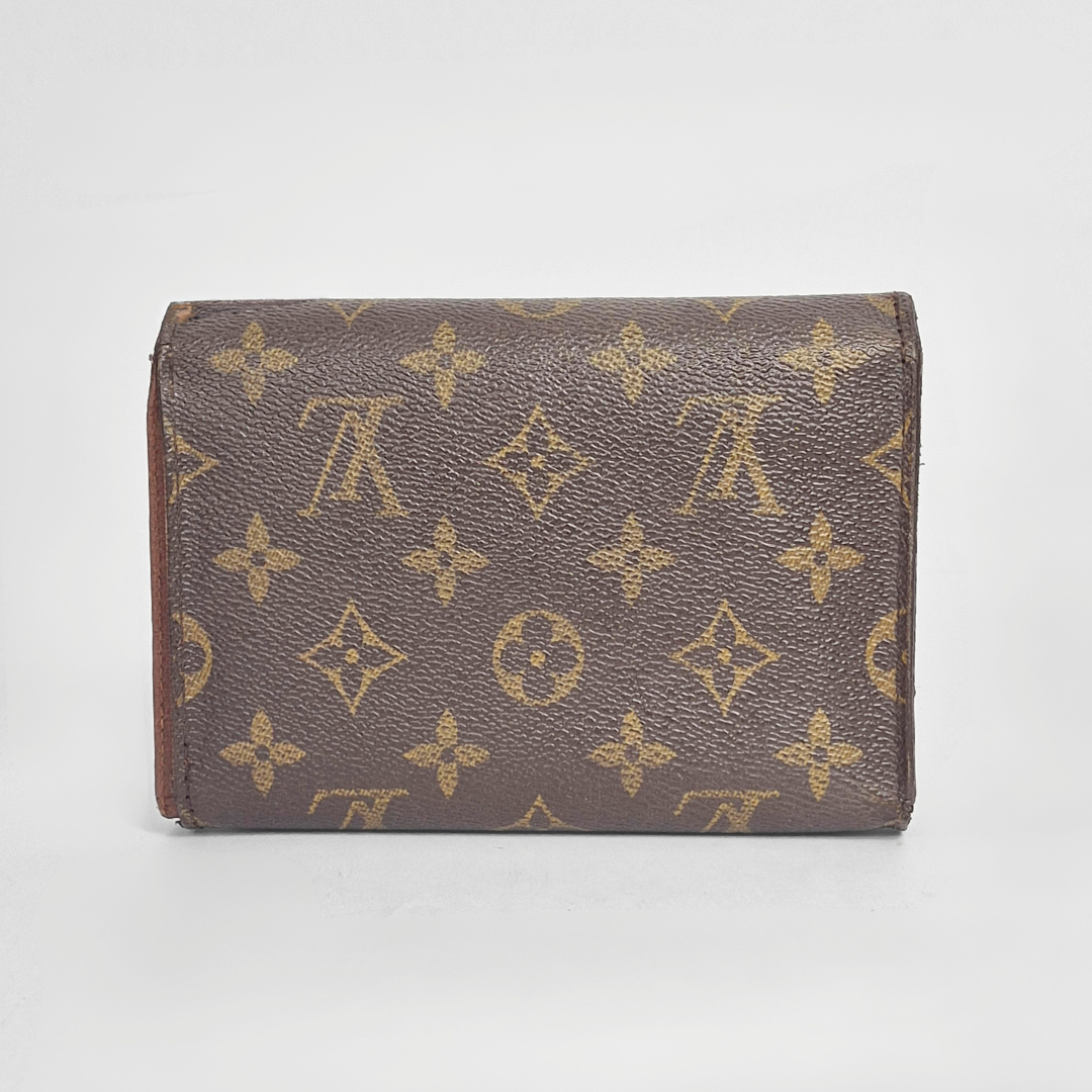 Brown wallet with gold monogram pattern on a light gray background
