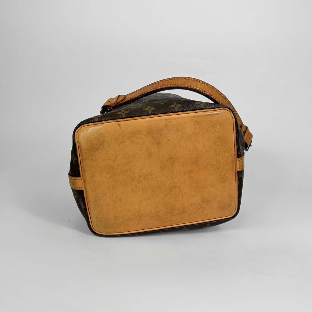 Brown leather handbag with monogram pattern on a light gray background