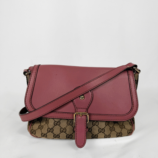 Un'annata Gucci Borsa a tracolla con patta e tracolla in pelle color rosa antico, abbinate al classico corpo in tela con monogramma GG marrone e beige, su sfondo bianco.