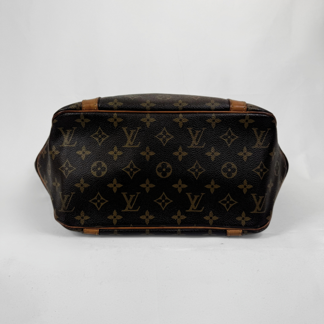 Louis Vuitton monogram canvas handbag shown from the bottom, featuring the classic dark brown and tan LV pattern with tan leather trim on a white background.