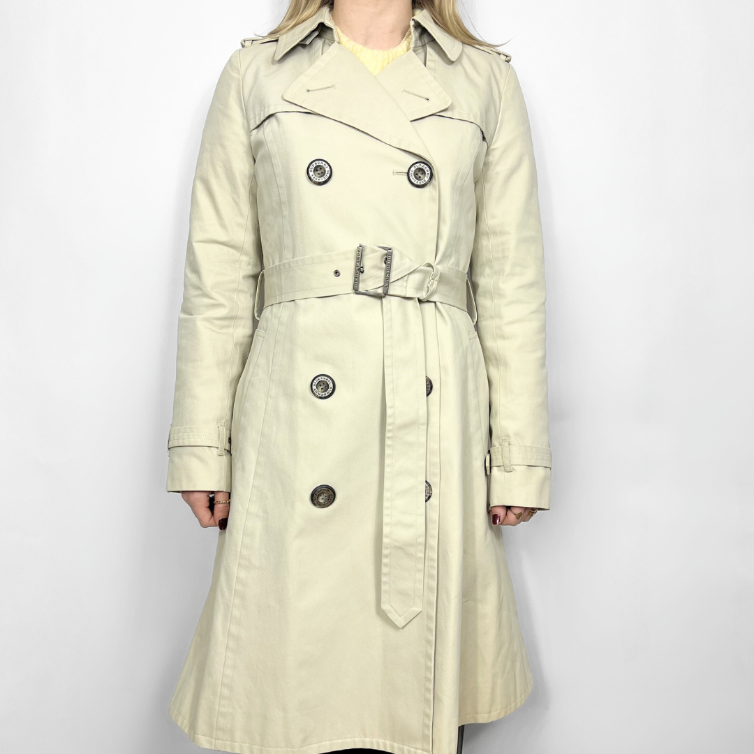 Beige trench coat worn by a person on a white background