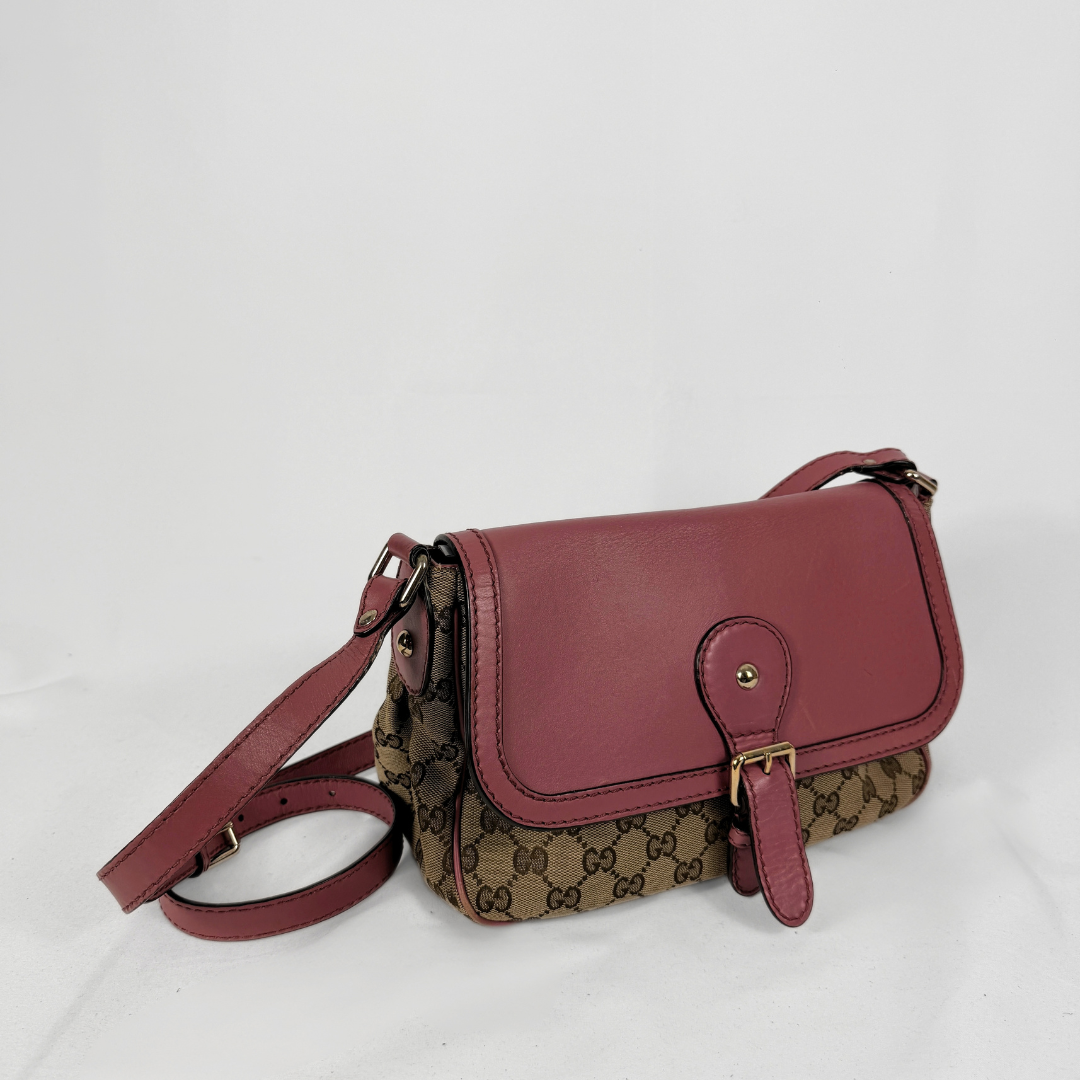 A Gucci shoulder bag featuring the brand's signature GG Supreme canvas in brown and beige, combined with a dusty rose leather flap and strap, accented by gold-tone hardware.