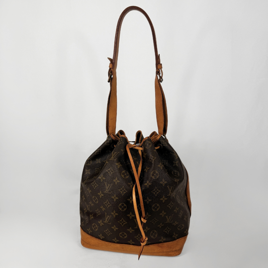 A Louis Vuitton monogram canvas bucket bag with brown leather trim, drawstring closure, and a single shoulder strap, photographed against a plain light gray background.