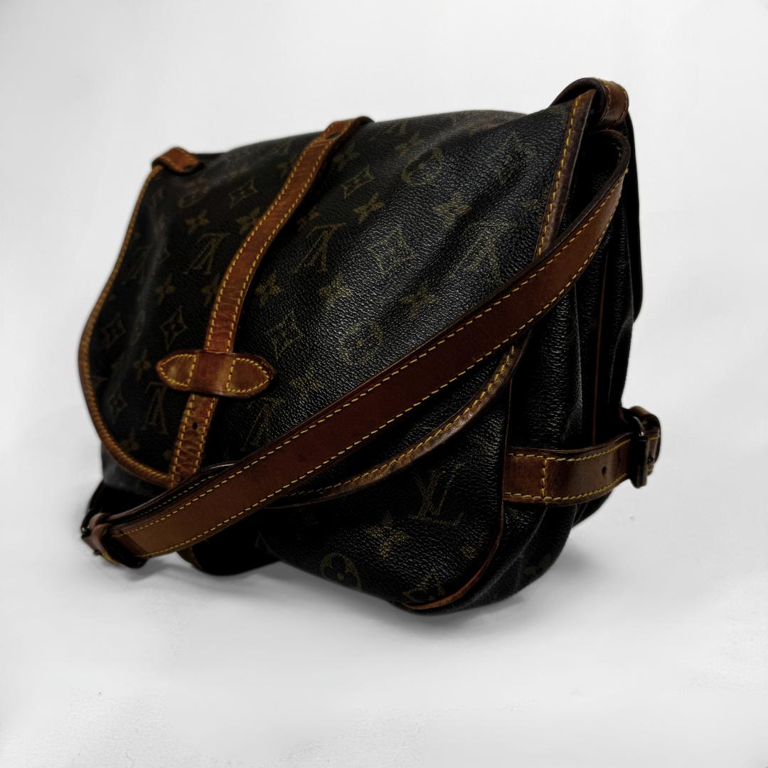 A vintage Louis Vuitton shoulder bag in brown monogram canvas with dark brown leather trim and strap, photographed on a white background.
