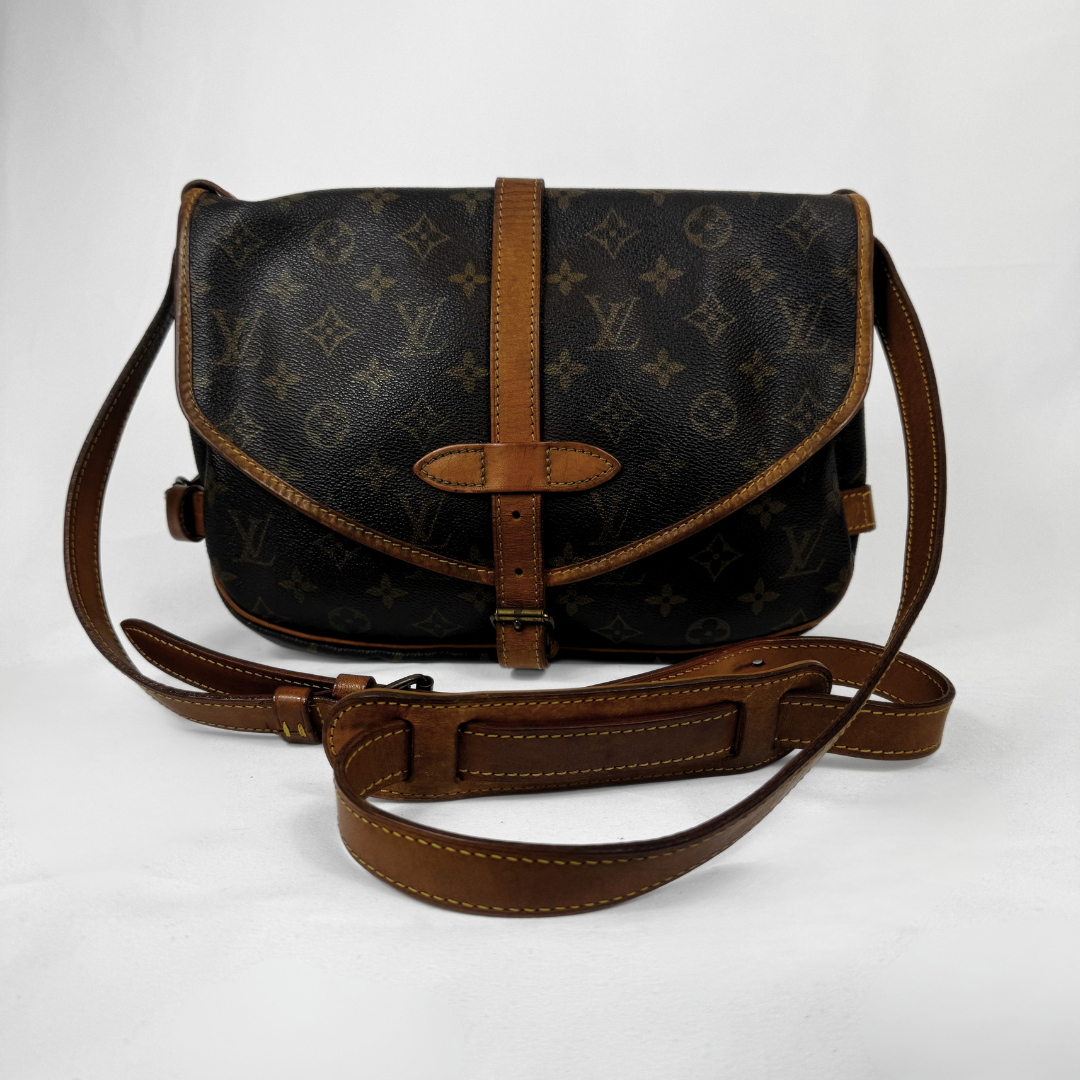 A Louis Vuitton monogram canvas shoulder bag with brown leather trim and strap, displayed on a light gray background.