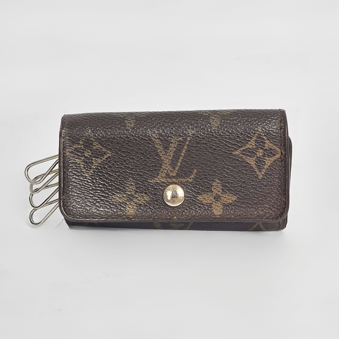Brown leather wallet with gold monogram pattern on a light gray background