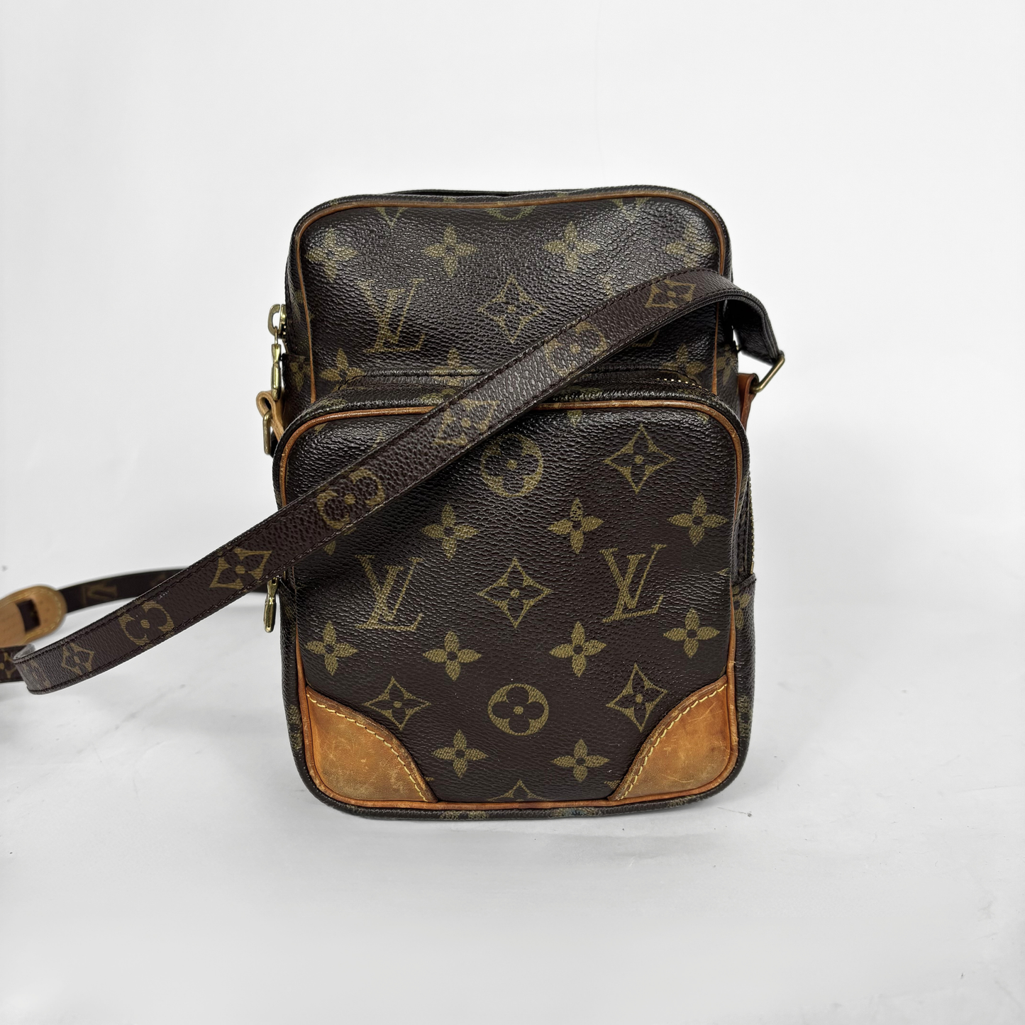 Brown leather bag with monogram pattern on a white background
