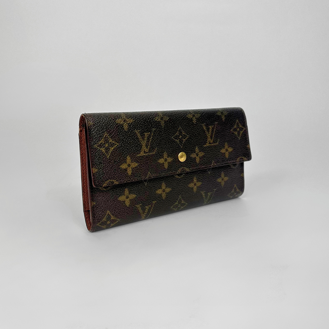 Louis Vuitton wallet with monogram pattern on a light gray background