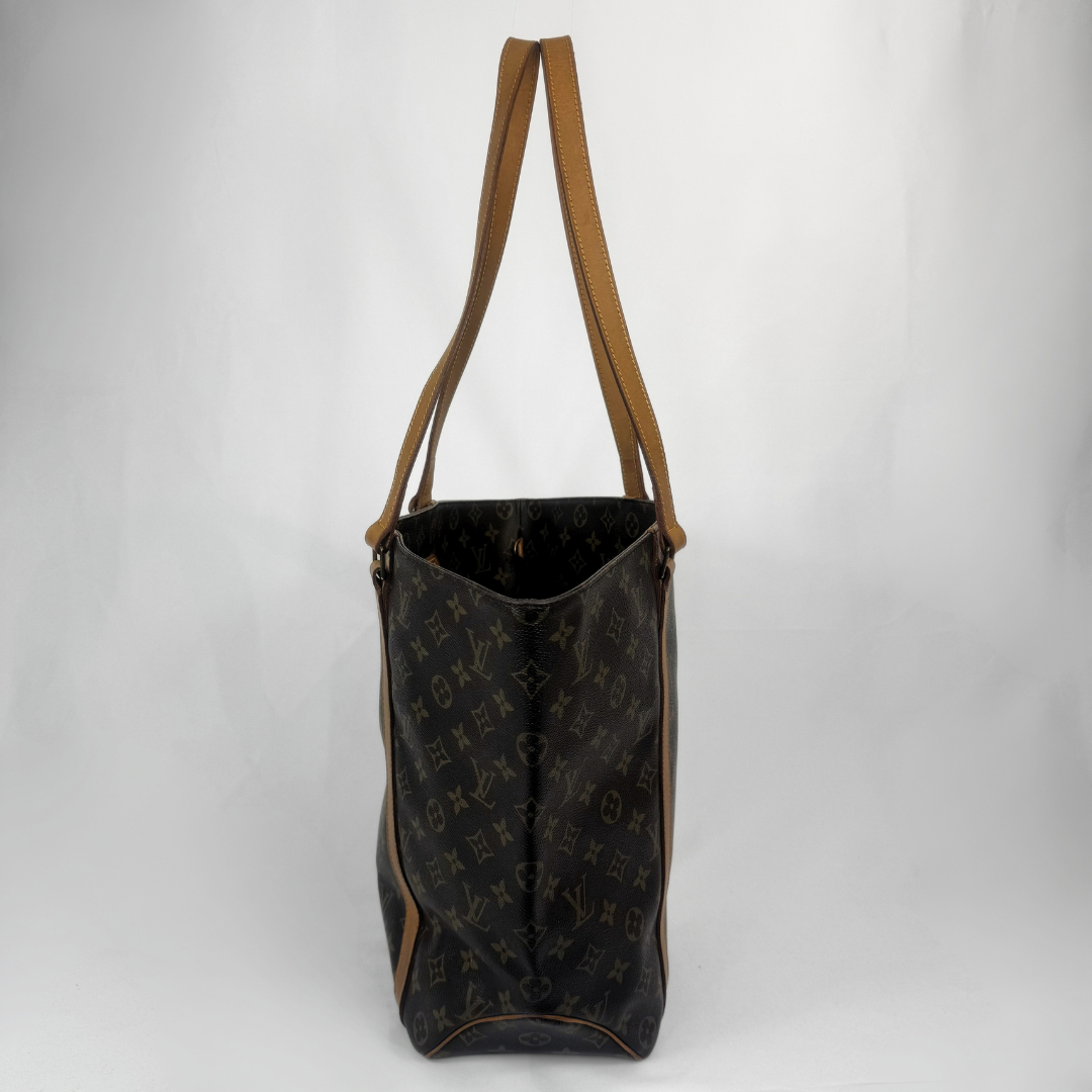 A Louis Vuitton monogram canvas tote bag with tan leather shoulder straps, shown against a plain light gray background.