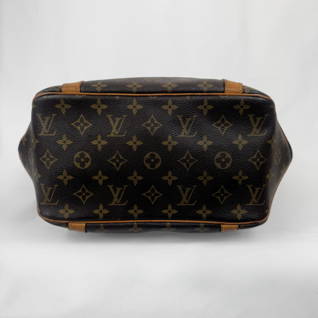 Louis Vuitton monogram canvas handbag shown from the back, featuring the classic dark brown and tan monogram pattern with light brown leather trim.