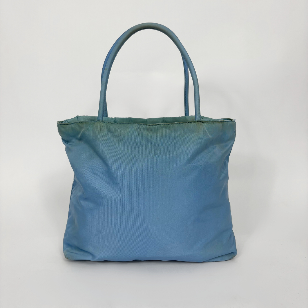 Prada Bolso tote de nailon azul claro con asas superiores a juego y el logotipo triangular esmaltado característico de la marca.
