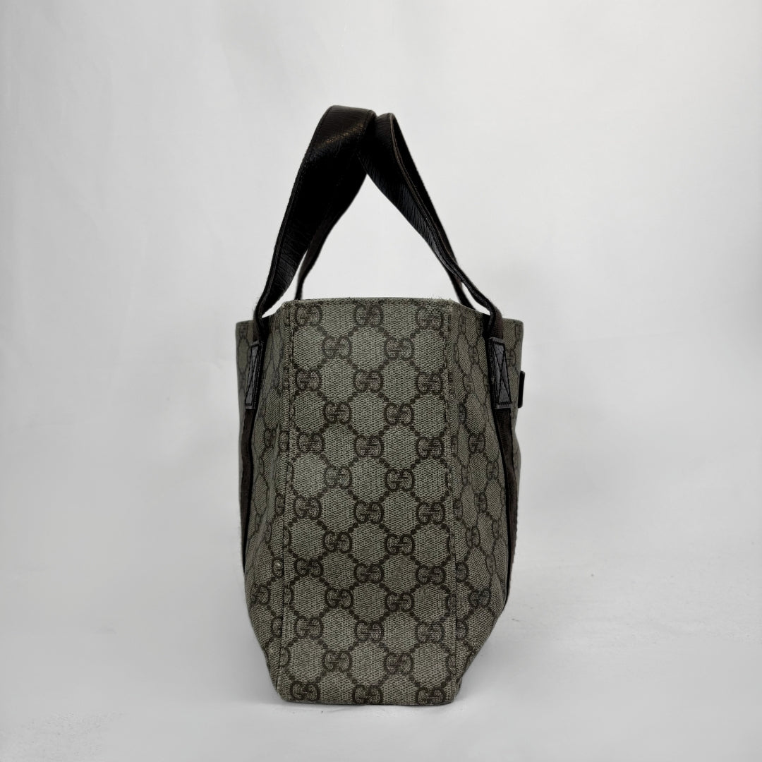 A vintage Gucci tote bag in the classic GG Supreme canvas, featuring a dark brown and gray monogram pattern with dark brown leather shoulder straps, shown against a plain light gray background.