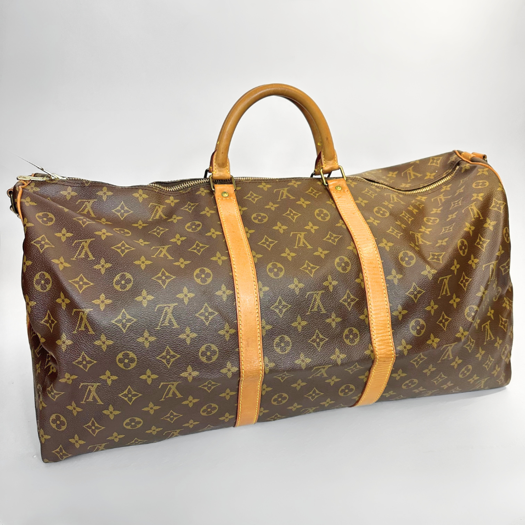 Brown travel bag with yellow monogram pattern on a white background