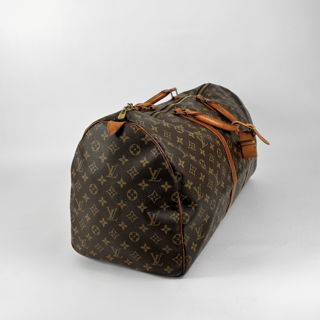 Brown Louis Vuitton travel bag with monogram pattern on a white background