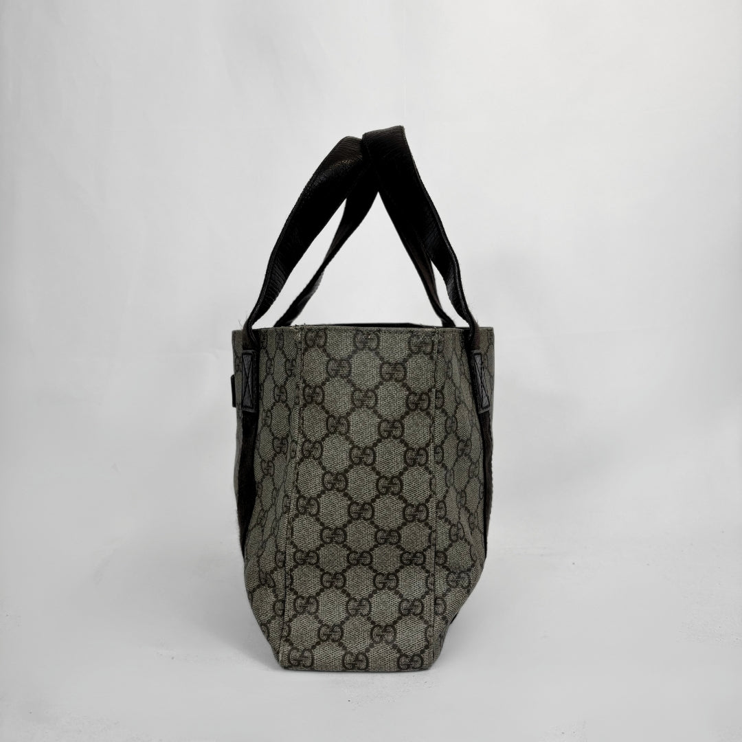 A vintage-style tote bag featuring the classic interlocking GG monogram canvas in gray and brown, with black leather shoulder straps and trim, photographed against a plain light gray background.