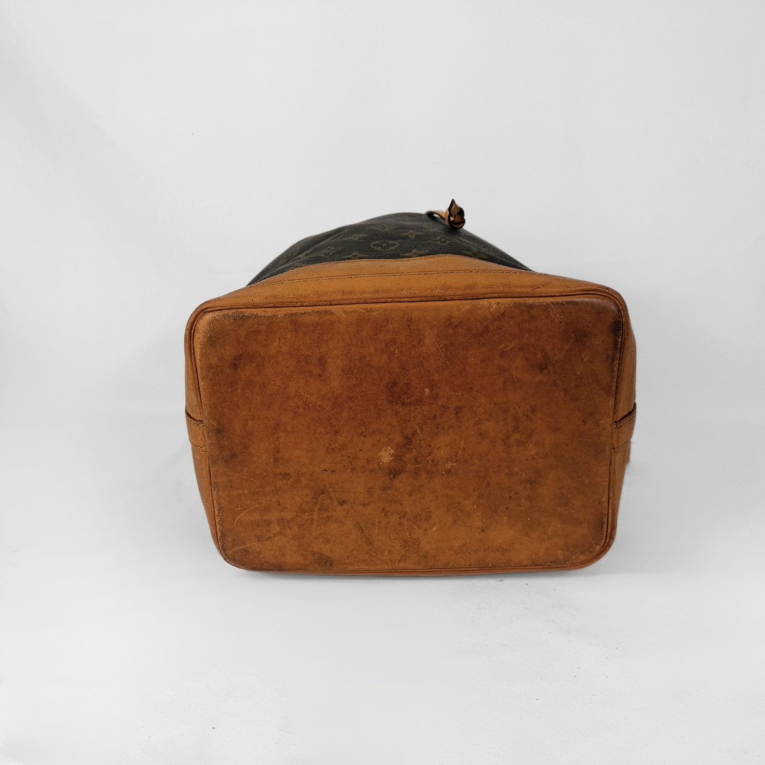 A vintage Louis Vuitton shoulder bag in brown leather with a black monogram canvas top, photographed from the back against a white studio background.