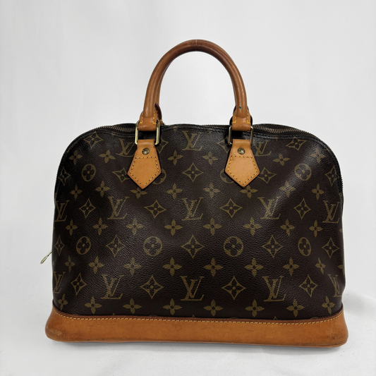 Louis Vuitton monogram canvas handbag with tan leather handles and trim, photographed against a plain light background.