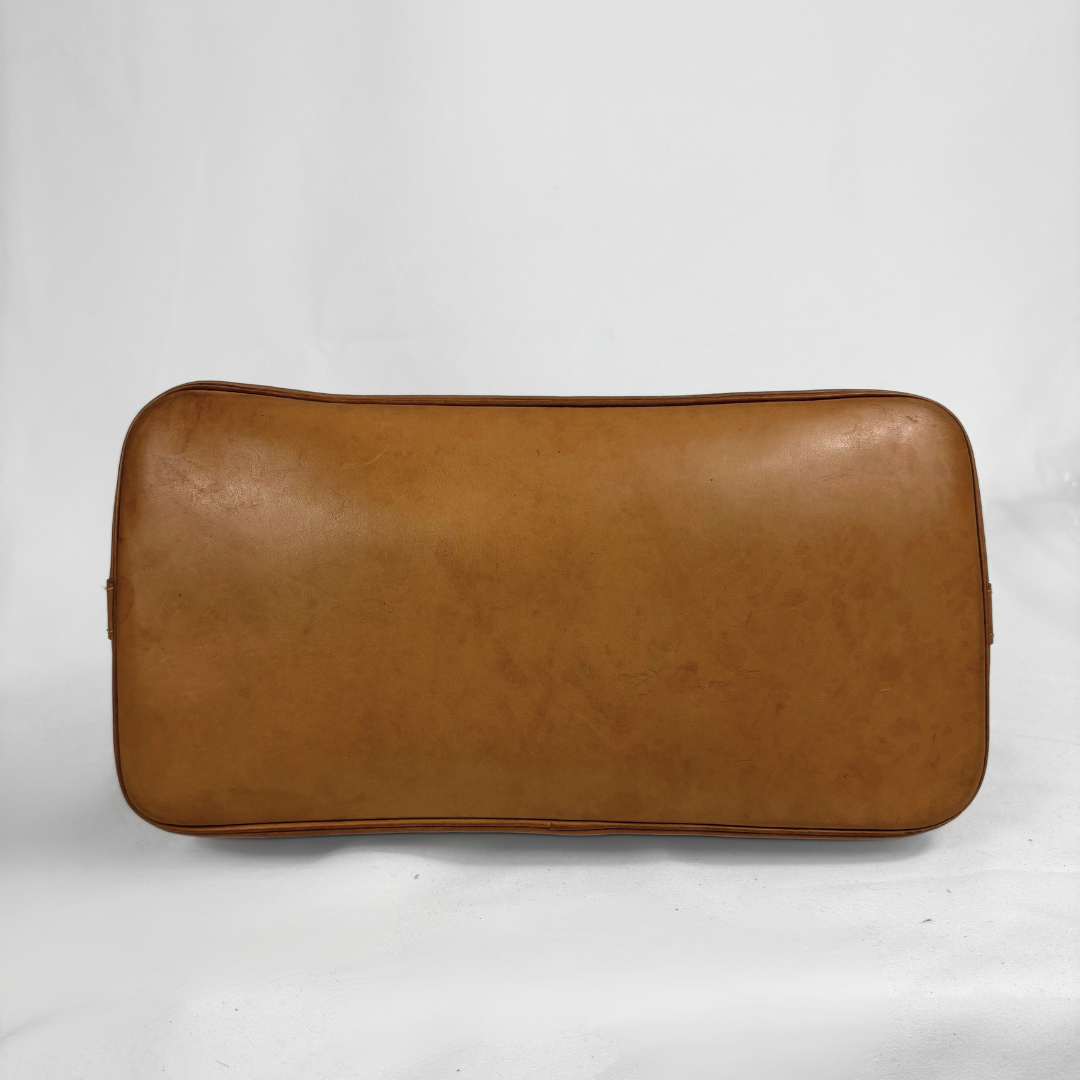 A rectangular tan leather pouch or case with rounded corners, photographed against a plain light gray background.