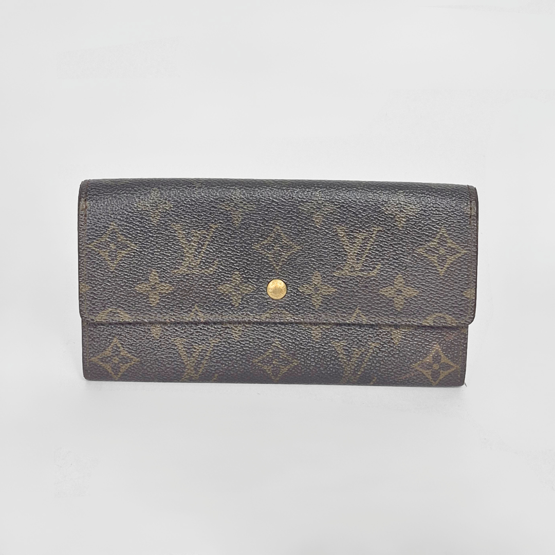 Louis Vuitton wallet with monogram pattern on a light gray background