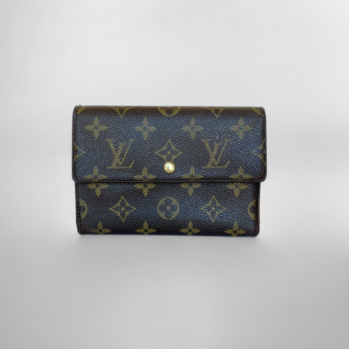 Louis Vuitton wallet with monogram pattern on a light gray background