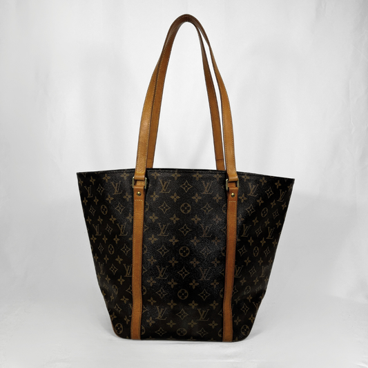 A Louis Vuitton monogram canvas tote bag with tan leather shoulder straps, photographed against a white studio background.