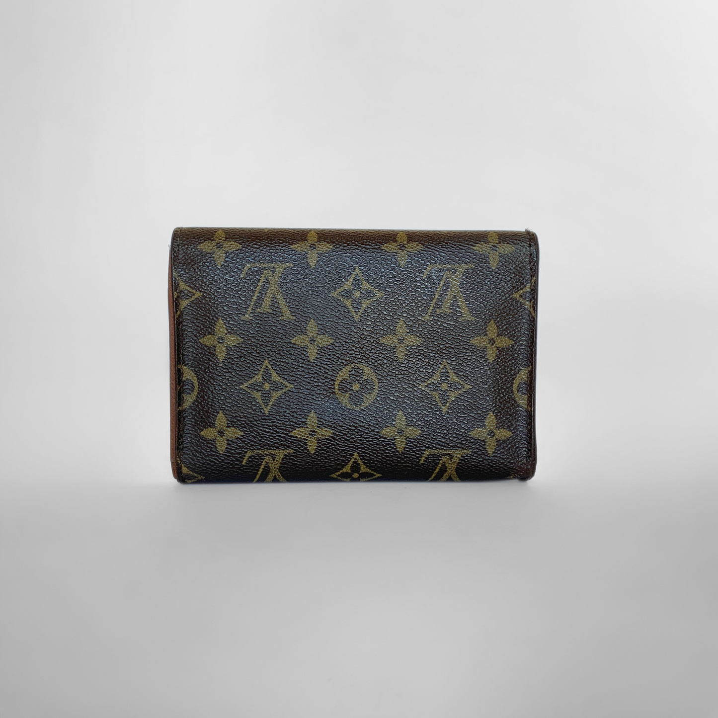 Louis Vuitton wallet with monogram pattern on a light gray background