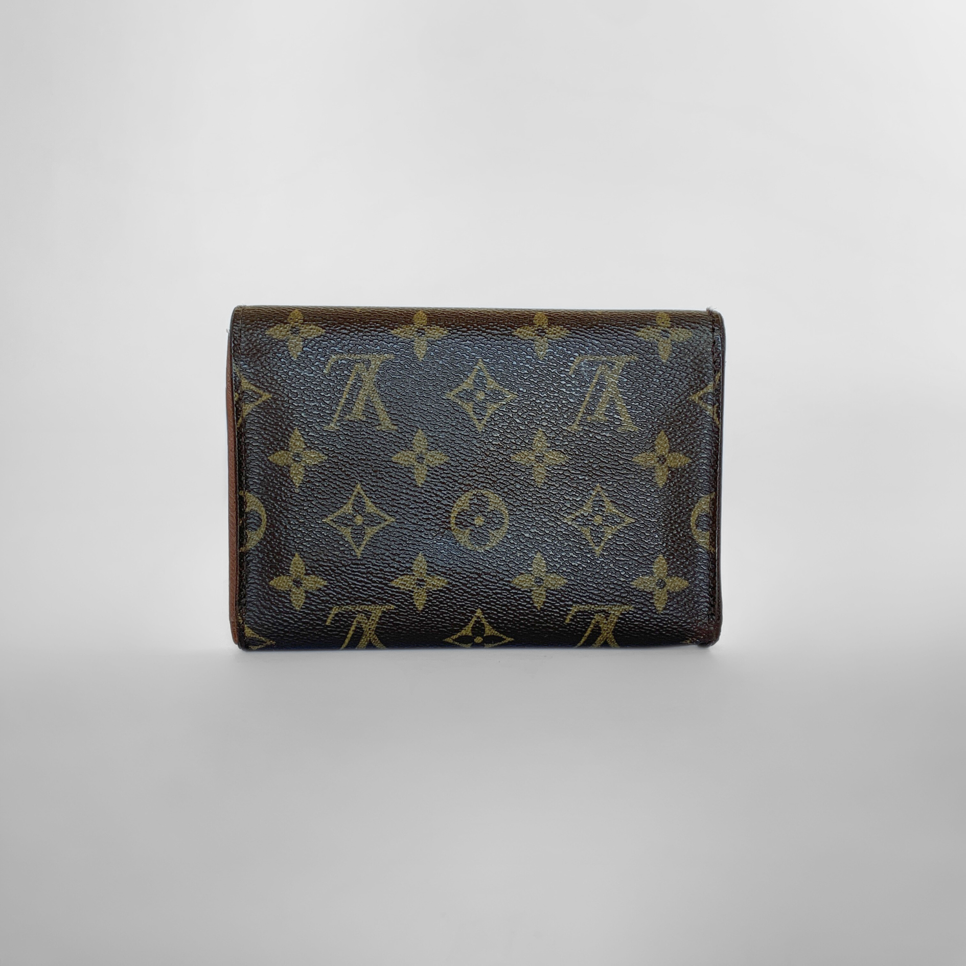 Louis Vuitton wallet with monogram pattern on a light gray background