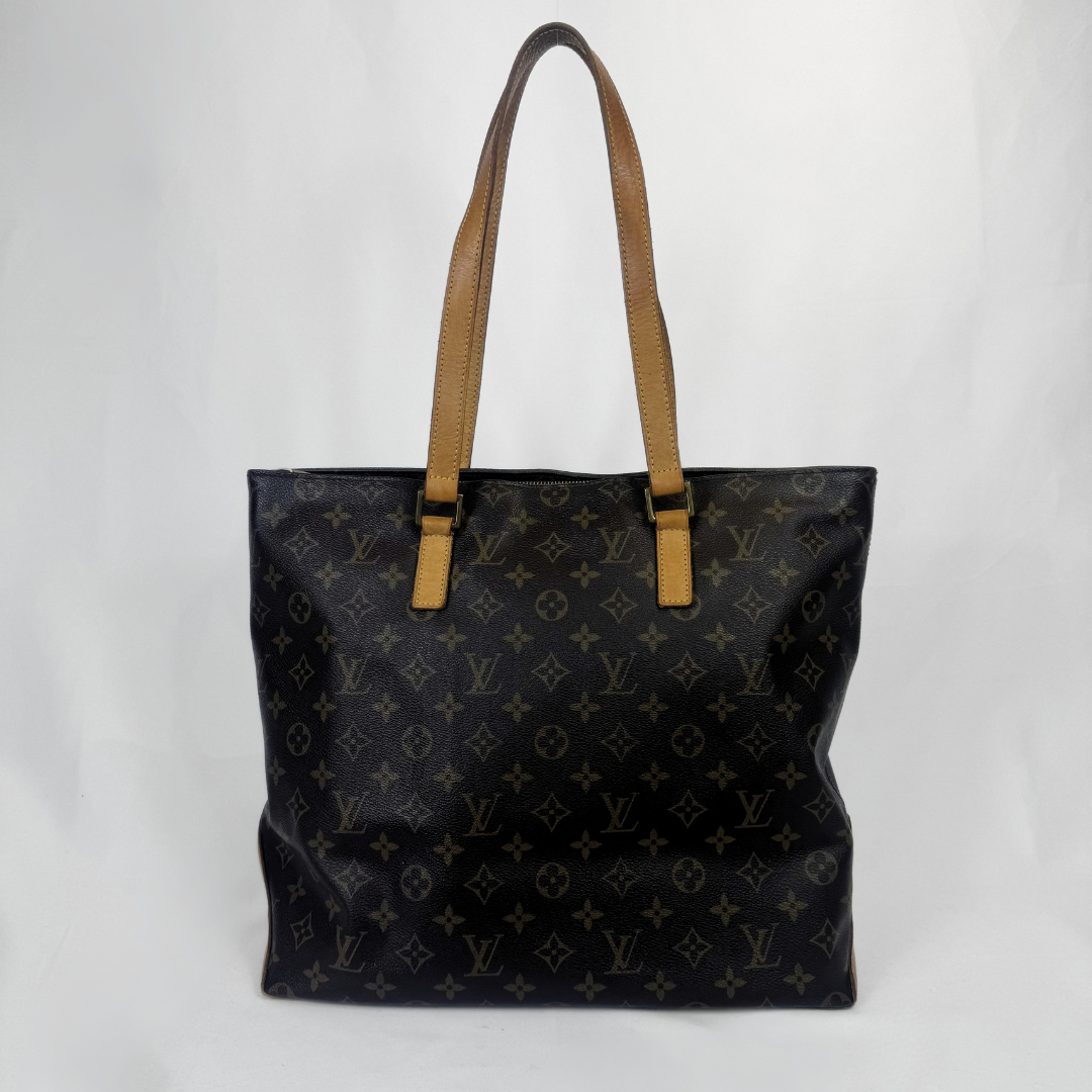 A Louis Vuitton black monogram canvas tote bag with tan leather shoulder straps, shown against a plain light gray background.