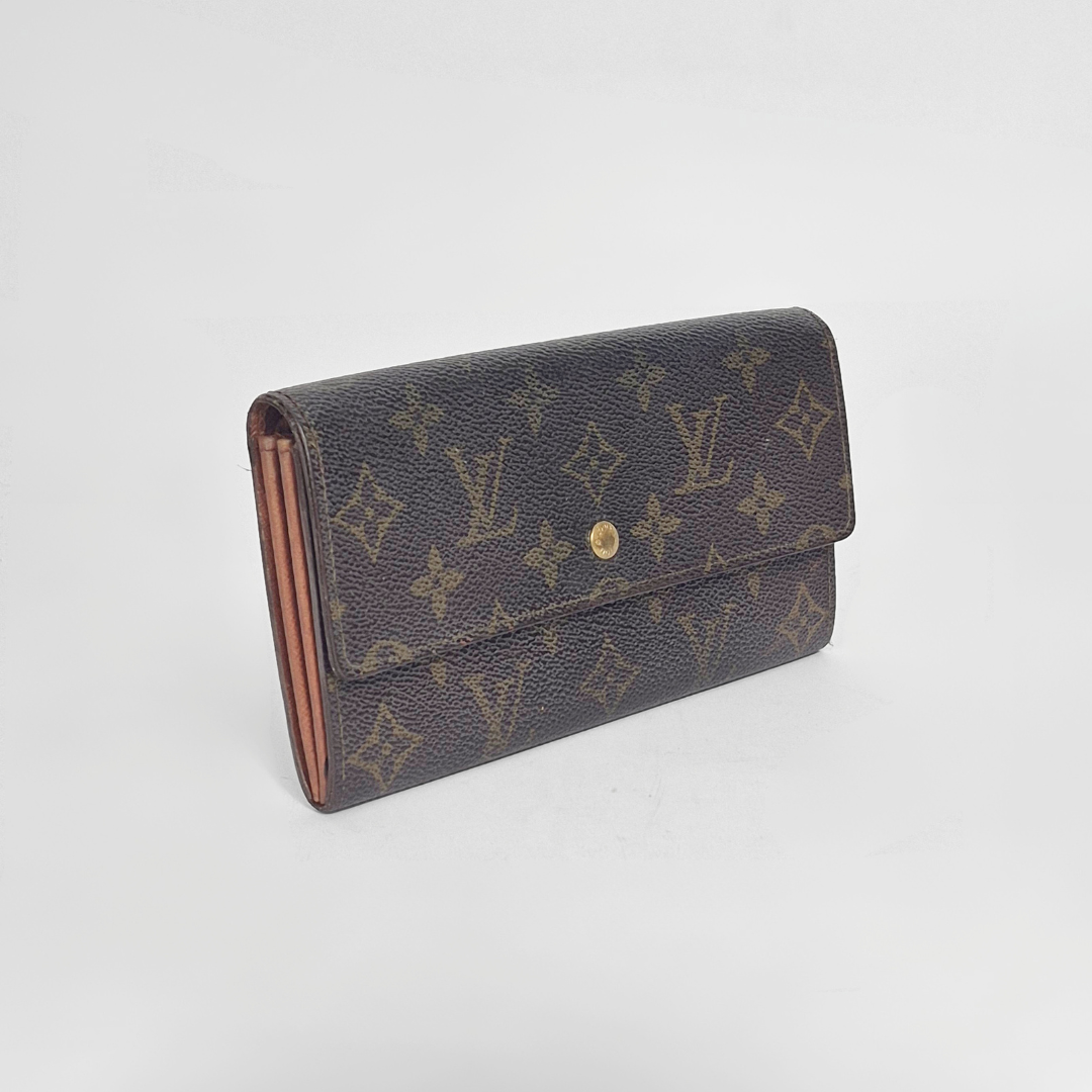 Louis Vuitton wallet with monogram pattern on a white background