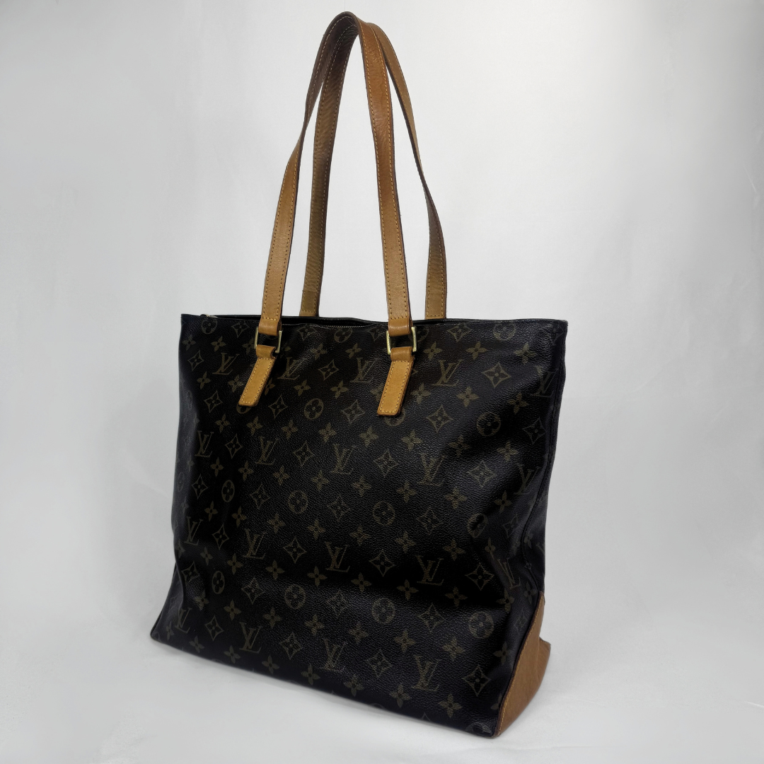 A Louis Vuitton black monogram canvas tote bag with tan leather shoulder straps and trim, shown on a light gray background.
