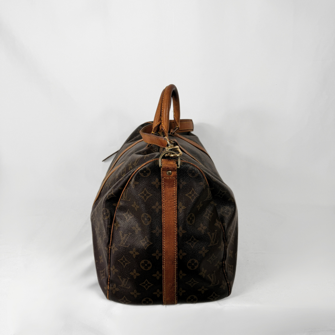 A Louis Vuitton monogram canvas duffel bag with brown leather trim and handles, photographed from the back against a white studio background.