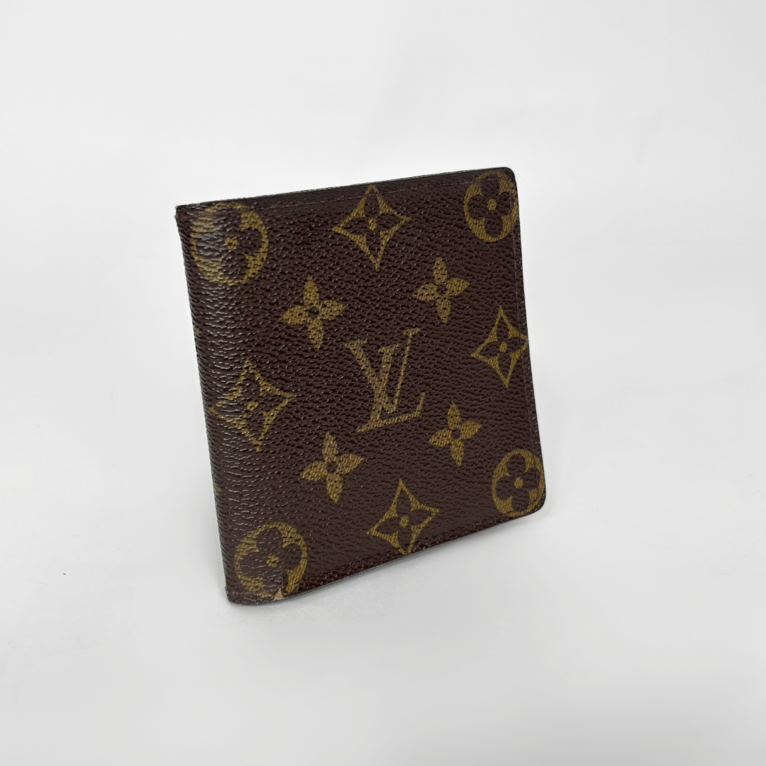 Brown wallet with gold monogram pattern on a white background