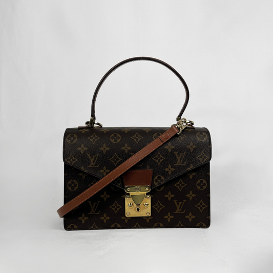 Louis Vuitton monogram canvas top-handle handbag with a brown leather shoulder strap and gold-tone hardware, photographed against a plain light background.