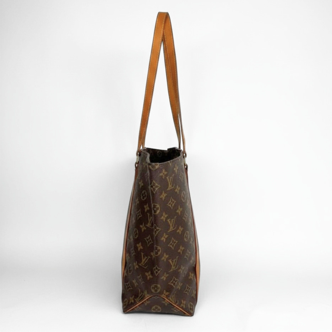 A Louis Vuitton monogram canvas tote bag with brown leather shoulder straps, shown from the side against a plain white background.