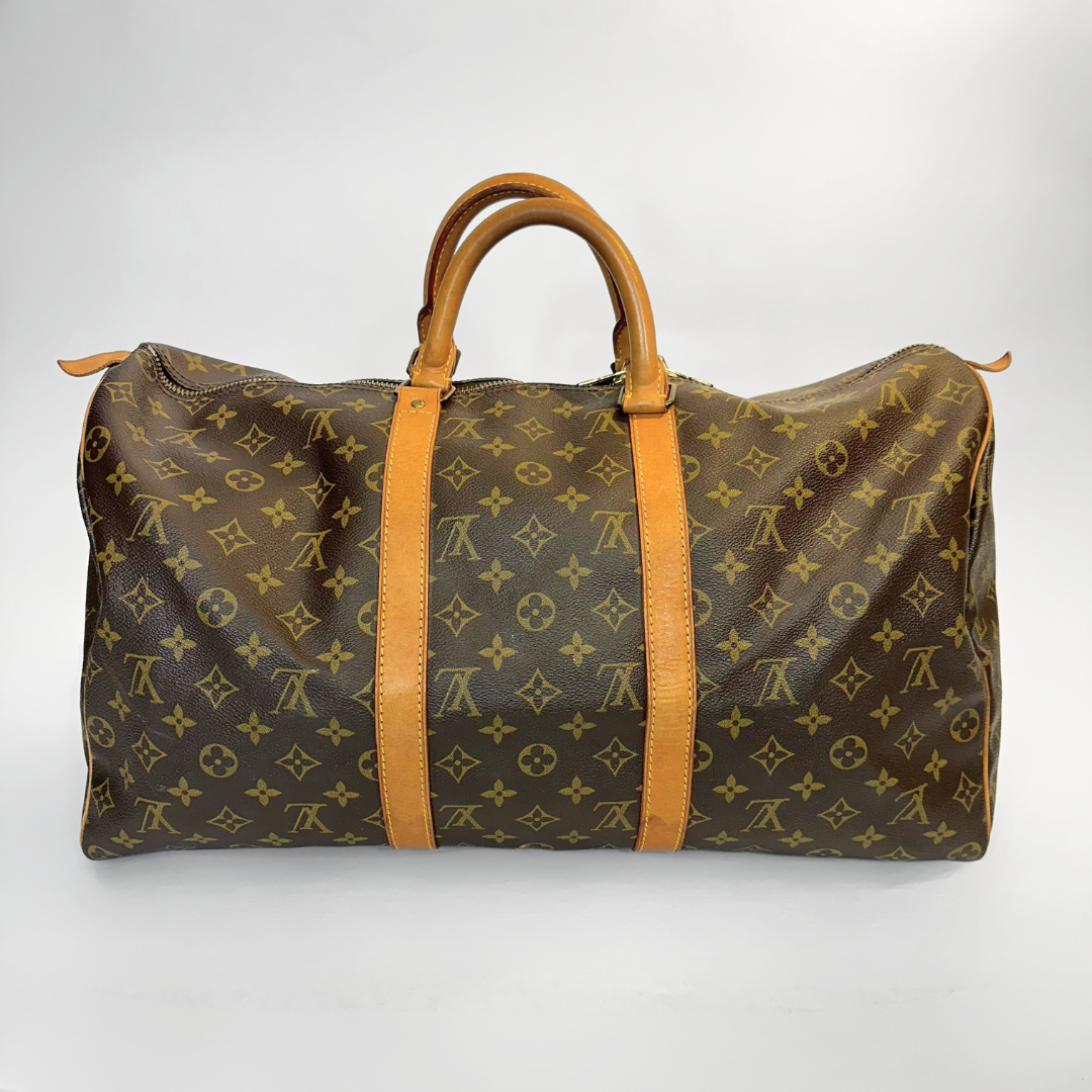 Bolso de viaje marrón con correas de cuero color canela sobre fondo blanco.