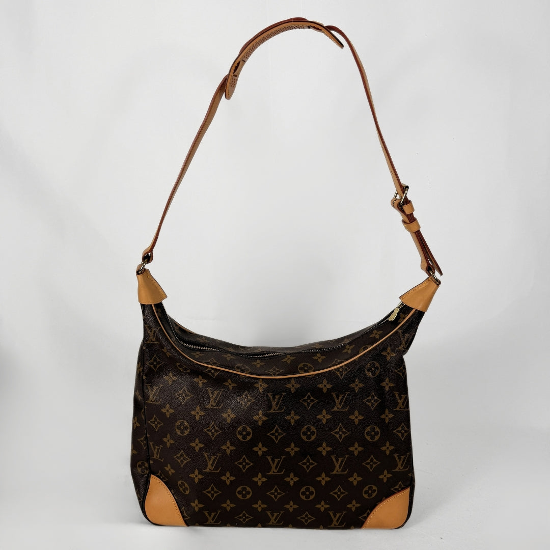 A Louis Vuitton monogram canvas shoulder bag with tan leather trim and corner protectors, shown against a plain light gray background.