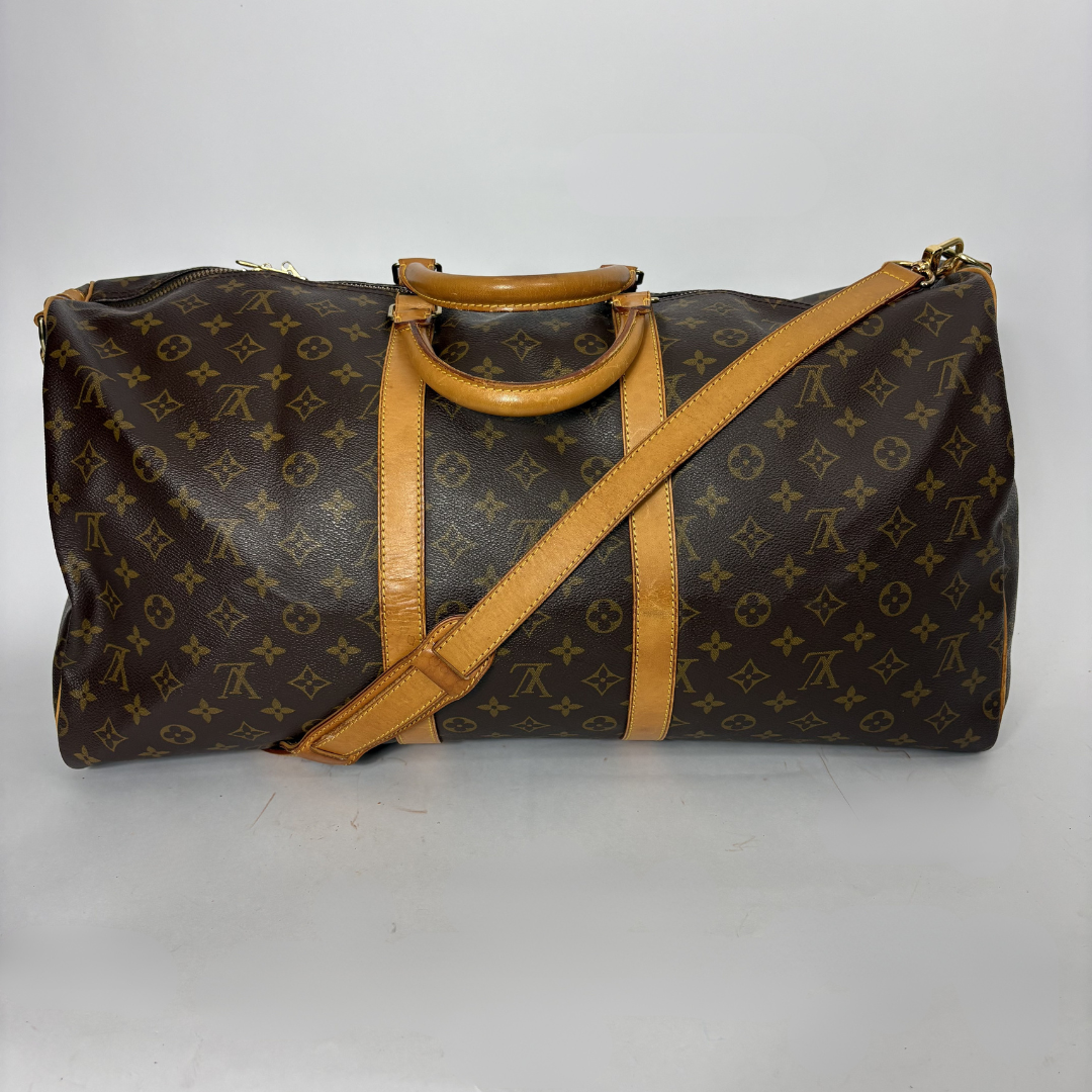 Brown leather duffel bag with tan straps on a white background