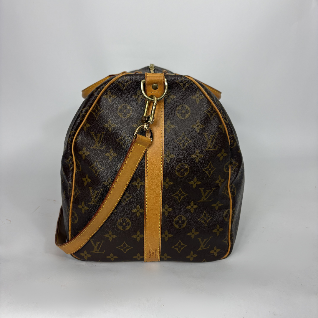 Brown leather duffel bag with tan straps on a white background
